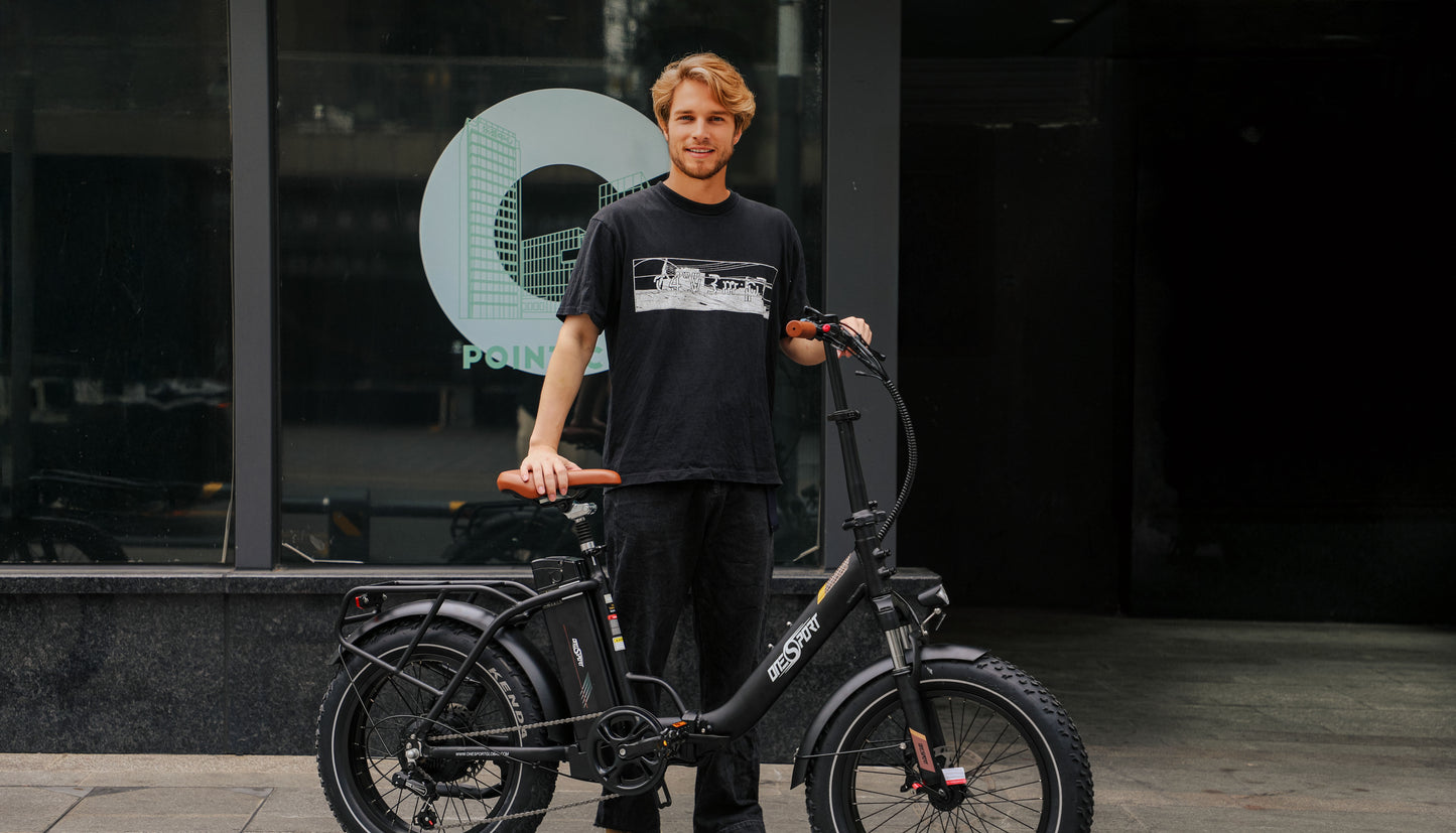 OneSport OT16 Max Elcykel svart med en kille som står och håller i elcykeln